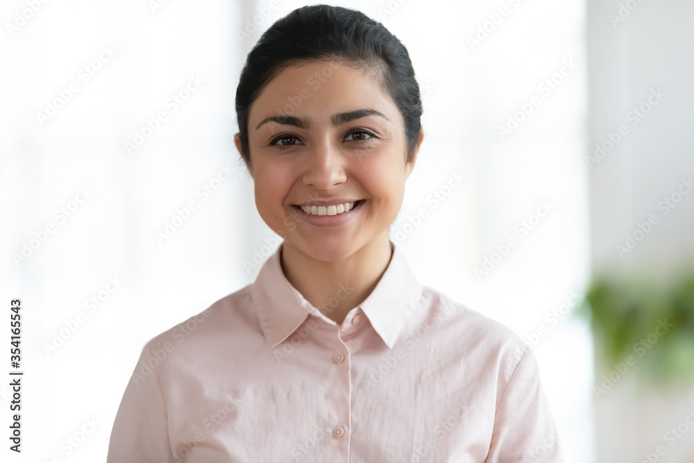 Head shot close up portrait of young indian businesswoman. Positive female millennial hindu ethnicity employee specialist professional looking at camera, posing for photo, human resources concept.