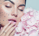 Beauty fashion Woman face decorated with gem stones, crystals. Closeup Portrait with Hydrangea. Model girl with holiday Glamour shiny professional make up with gems, jewellery, jewelry, accessories