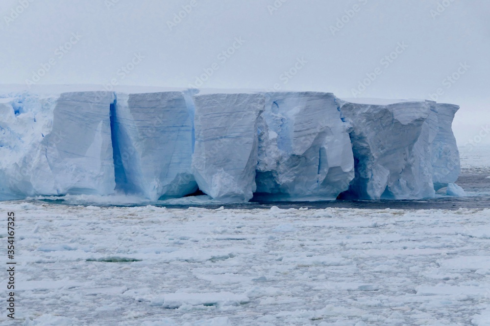 Closeup of blue iceberg at edge of pack ice in antarctic ocean, Antarctica