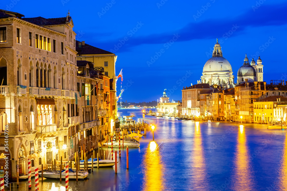 Basilica Santa Maria della Salute, Punta della Dogona and Grand Canal at blue hour sunset in Venice, Italy with reflections.