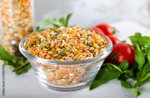 Colorful various beans or lentils and whole grains seeds or cereal in bowl with fresh vegetables.