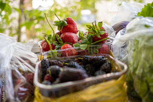 Strawberry and mulberry in the plastic bowl with yellow plastic bag and others vegetables