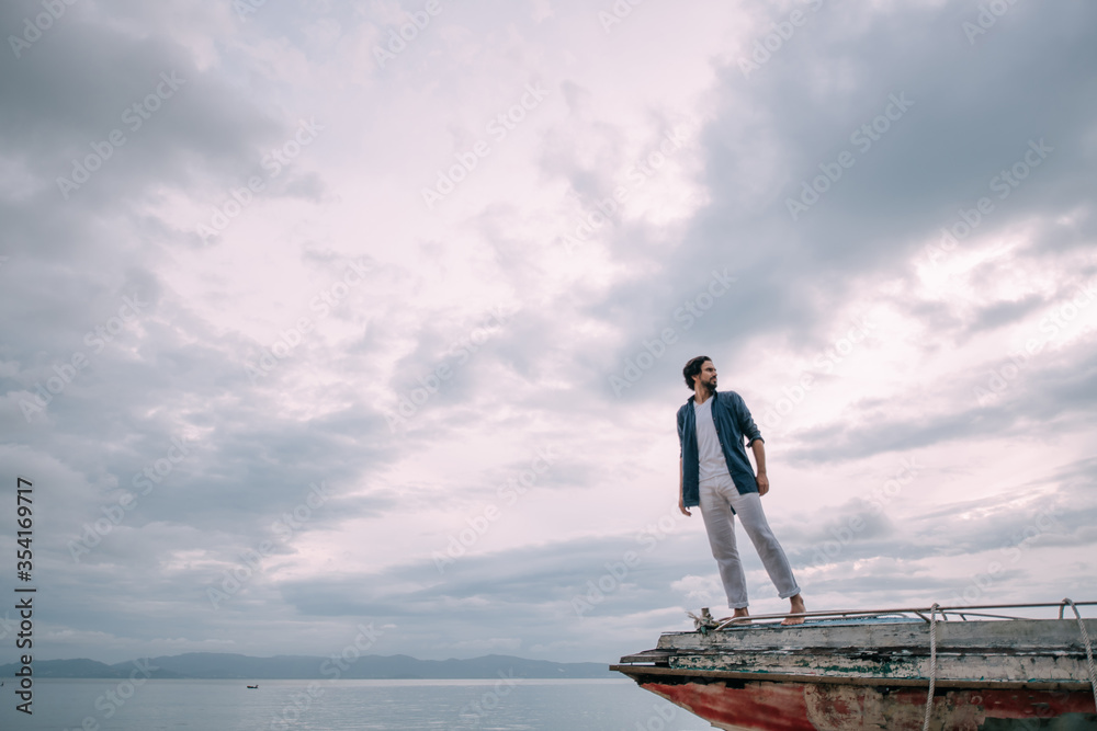 A lonely man walks along the beach on a cloudy day