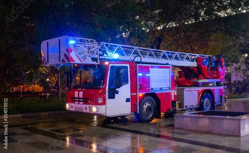 Fire engines in the courtyard of the apartment building where the fire occurred, at night during the rain.