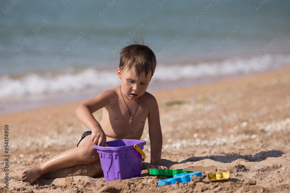 little boy playing on the beach with sand little boy playing on the beach with sand