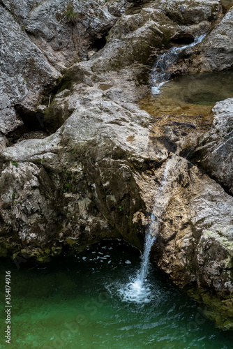Clear And Fresh Water Flows From Mountain Spring Into River