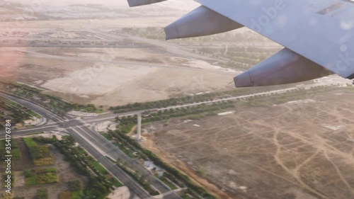 View from the left side window of an airplane on final approach to the Abu Dhabi International Airport at low altitude during sunset, passing an IKEA store. photo