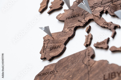 A wooden map of the world is glued to the wall on it marks with countries that have visited