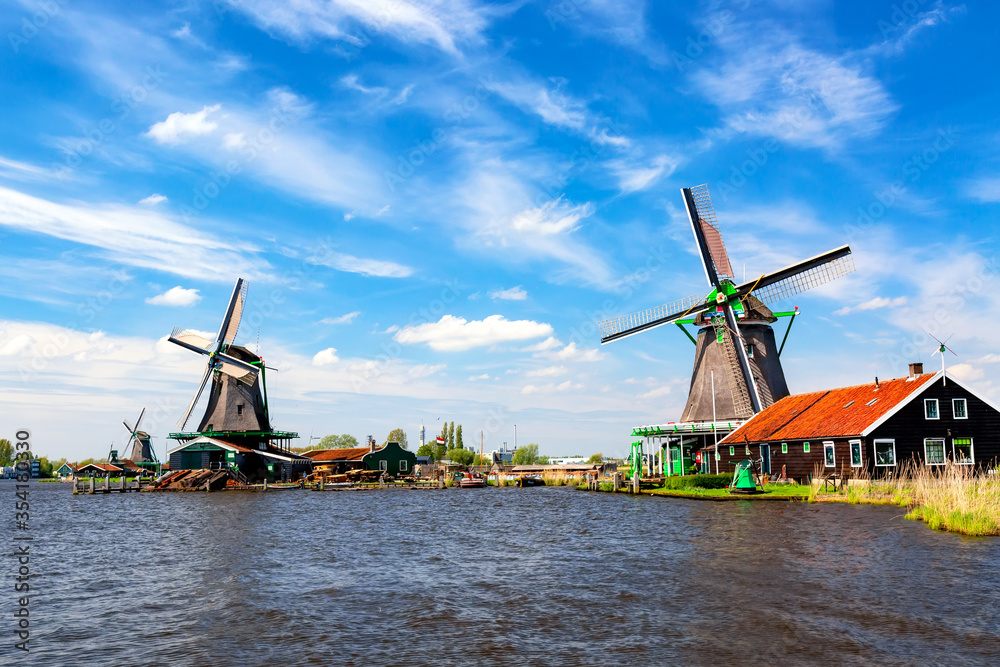 Typical iconic landscape in the Netherlands, Europe. Traditional windmills with a river in Zaanse Schans village. Famous tourist attraction in Holland