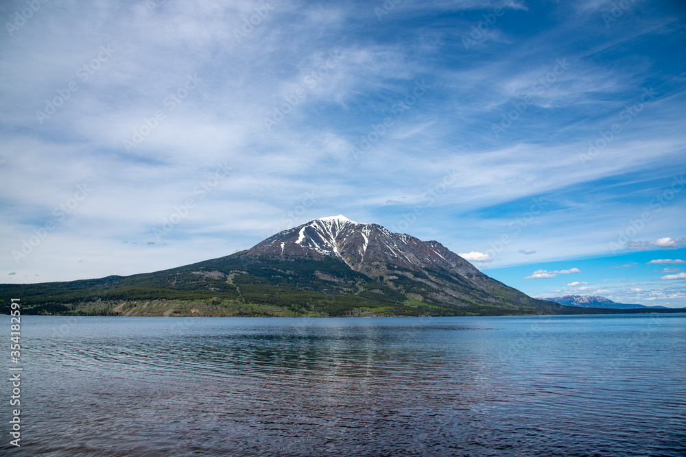 Beautiful singular mountain in Northern British Columbia near Yukon Territory border. Snow capped on the side of a calm, pristine lake. Beautiful singular mountain in Northern British Columbia near Yukon Territory border. Snow capped on the side of a calm, pristine lake.