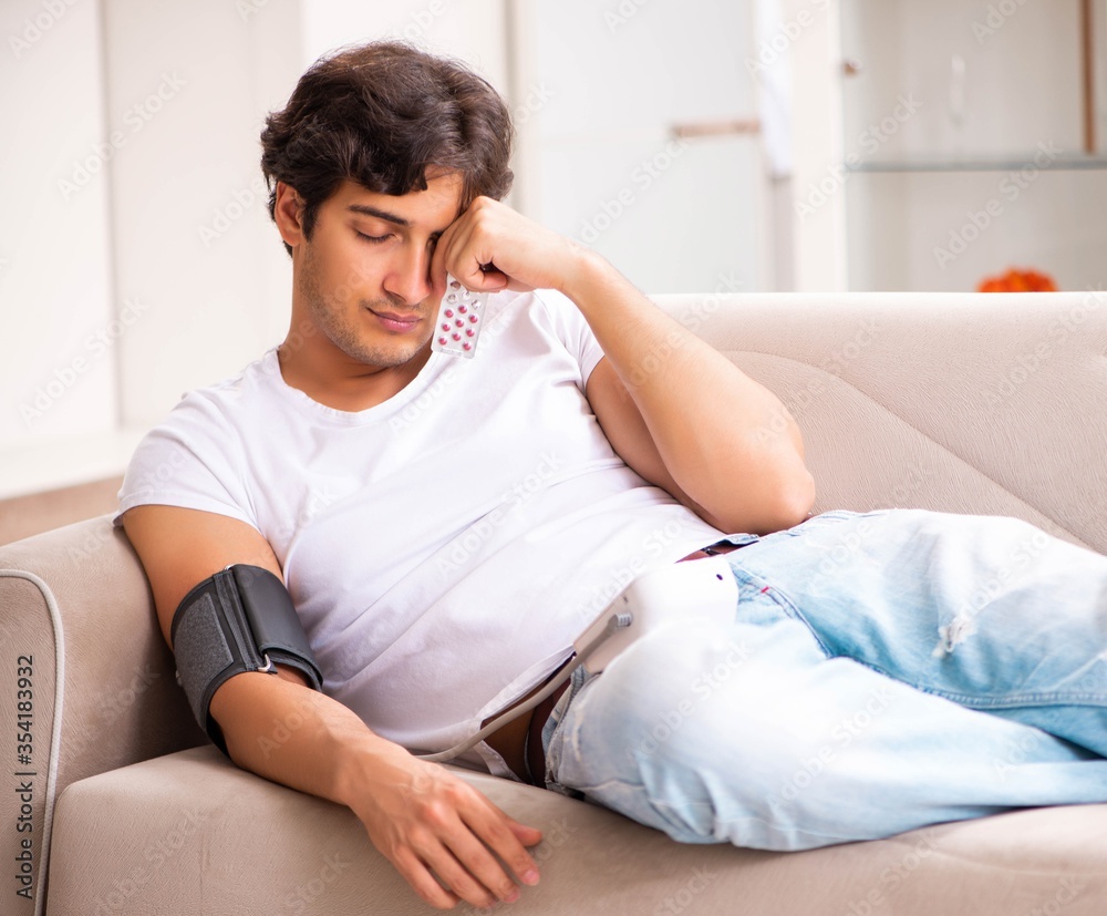 Young man measuring blood pressure at home Young man measuring blood pressure at home