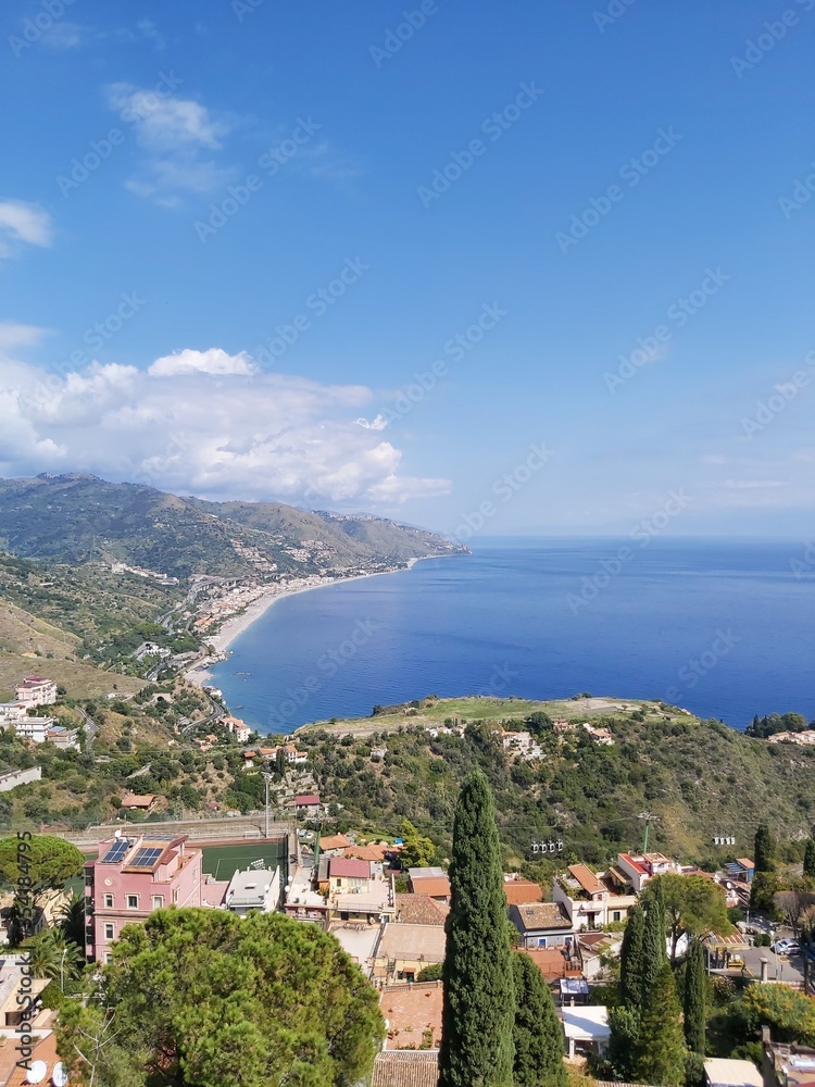 view from the sea, mountains and sea coast, beach and beach town, houses by the sea, bay in the east of Sicily, Italy, bay, blue sea