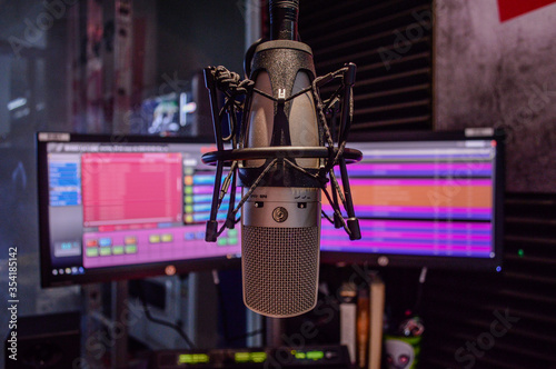 Konstfotografi micrófono al centro con monitores al fondo en cabina de radio