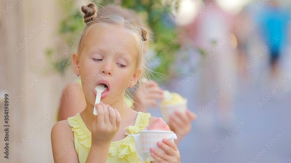 Adorable little girl eating ice-cream outdoors at summer. Cute kid enjoying real italian gelato near Gelateria in Rome Adorable little girl eating ice-cream outdoors at summer. Cute kid enjoying real italian gelato near Gelateria in Rome