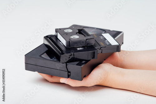 Schilderij op canvas close up, video cassette in child hand, isolated on white background, old gadget