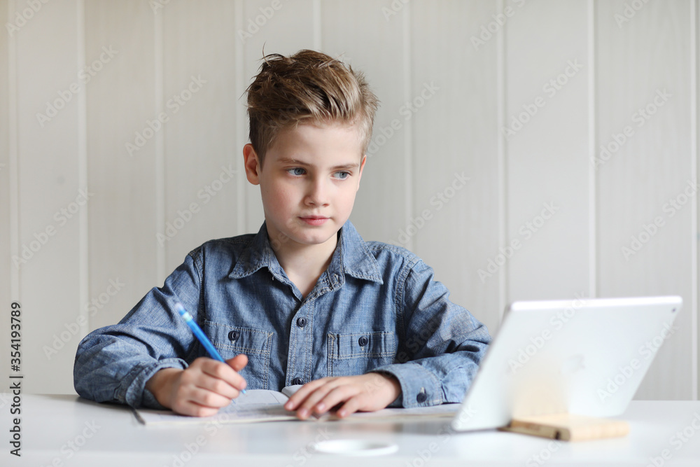 School boy watching online education classes at home. COVID-19 pandemic forces children online learning. School boy watching online education classes at home. COVID-19 pandemic forces children online learning.