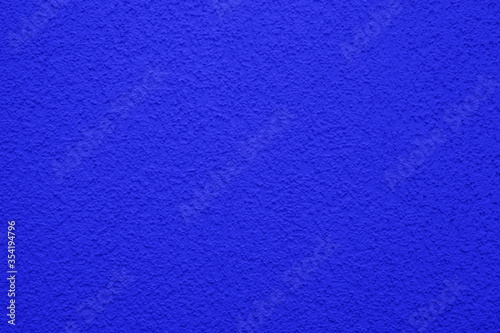 Bright, colorful concrete wall texture, painted background - blue color. Wallpaper plaster.