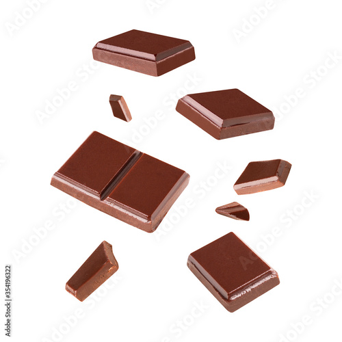 Three dark chocolate pieces Blast pieces in the air on a white background .Clipping path