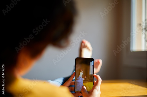 mujer joven haciendo selfie de pies encima de la mesa