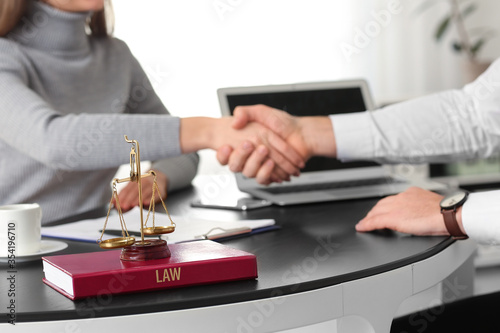 Woman and lawyer shaking ha...
