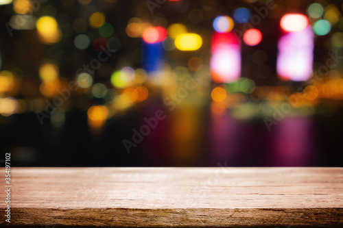 Empty wooden table space platform and blurred night city or dining background for product display montage