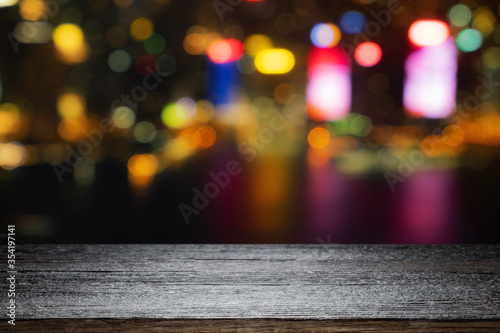 Empty wooden table space platform and blurred night city or dining background for product display montage