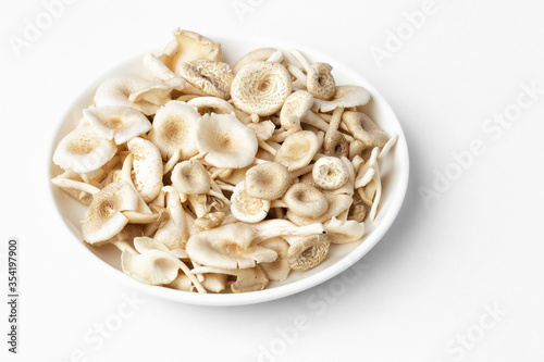 fresh whole mushrooms in a dish on white background