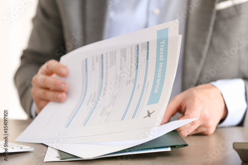 Male agent with travel insurance form, closeup