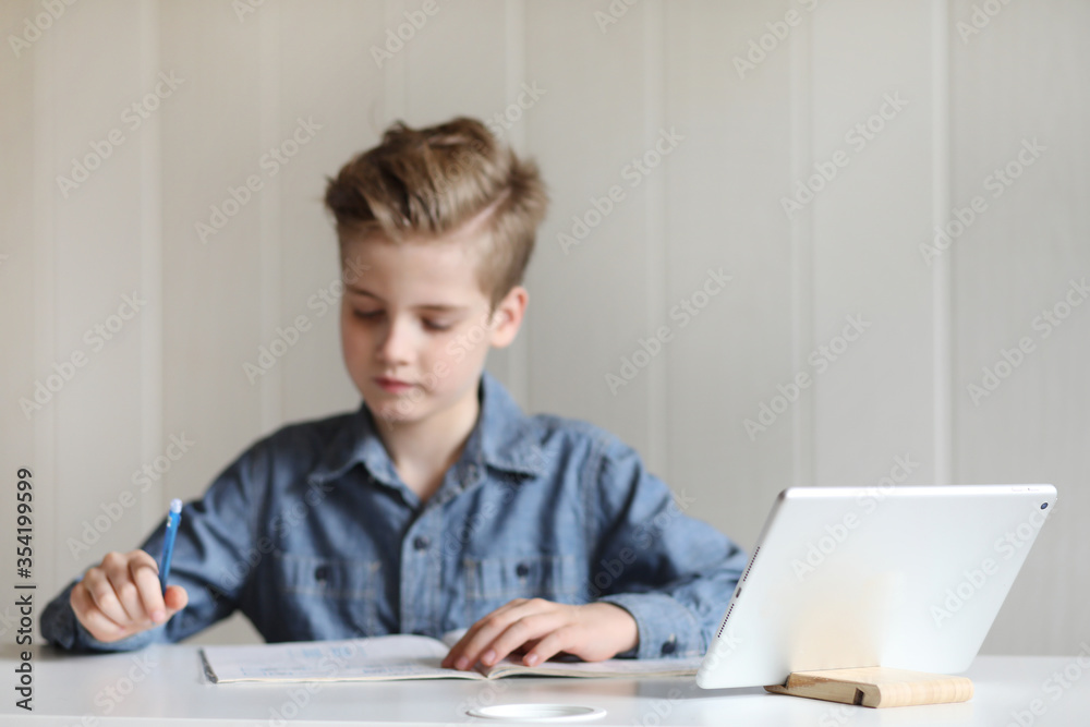 School boy watching online education classes at home. COVID-19 pandemic forces children online learning. School boy watching online education classes at home. COVID-19 pandemic forces children online learning.