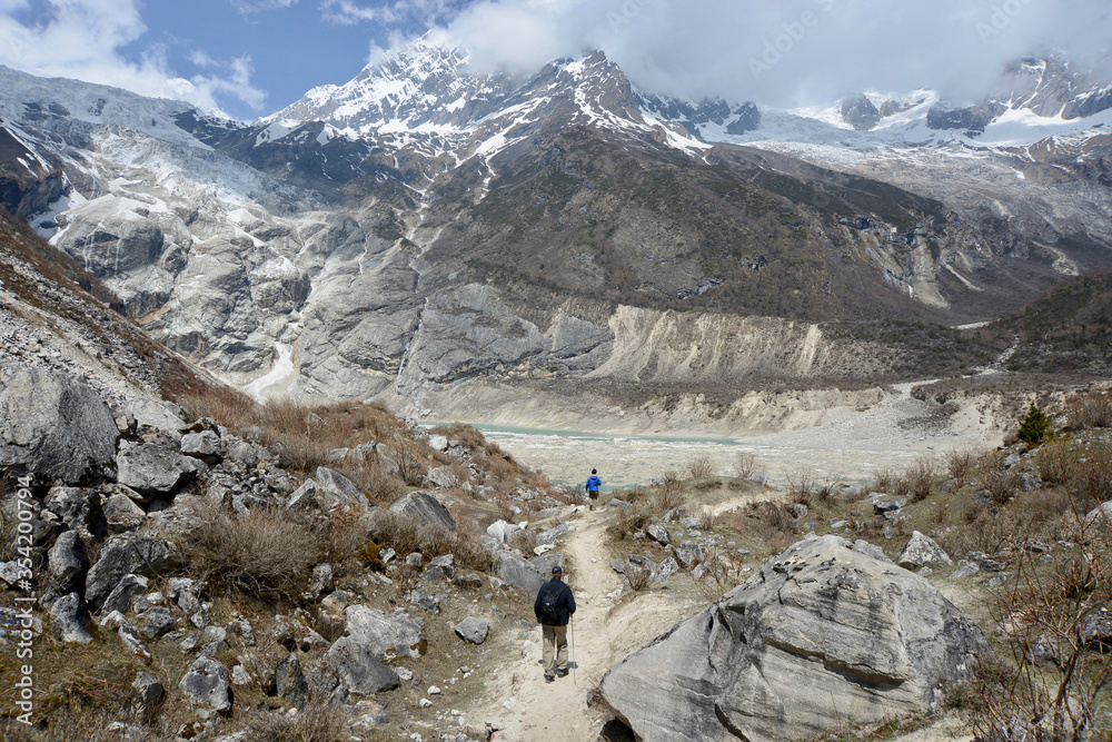 Hikers on their way to an alpine lake high in the Himalayas along the Manaslu Circuit trek in Nepal