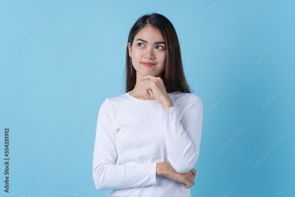 happy asian young woman in white fashion dress getting an ideas isolated on blue background. happy asian young woman in white fashion dress getting an ideas isolated on blue background.