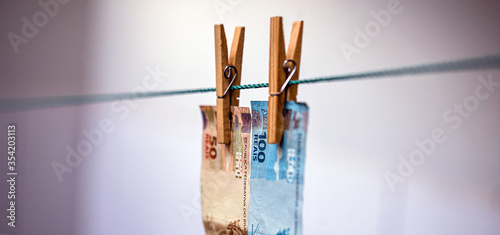 100 and 50 reais bank note on the drying line. Dirty money being laundered, concept of corruption in brazil