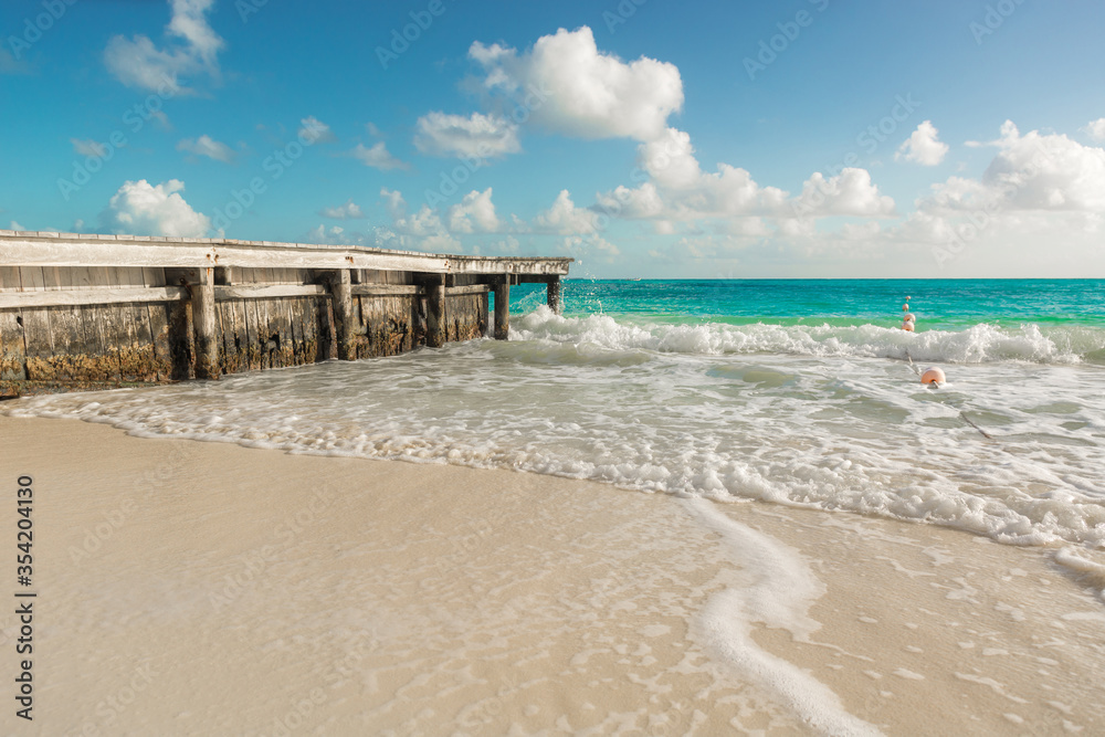 Wooden pier with blue sea and blue sky on background.