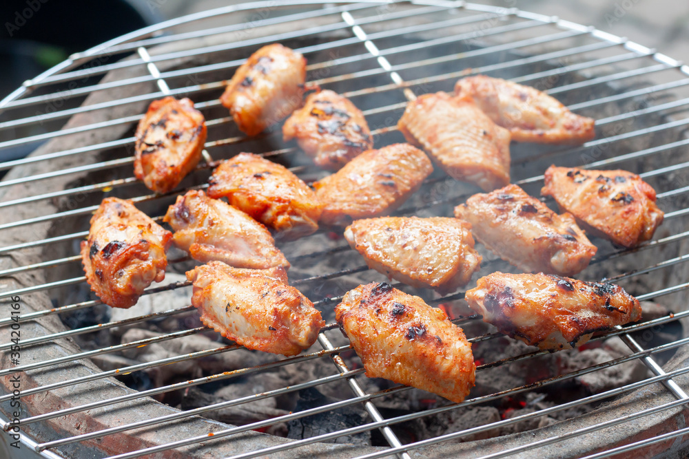 Grilled chicken wings on the grill with smoke lit floating.