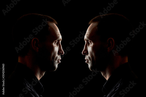 Serious man in a black shirt on a dark background