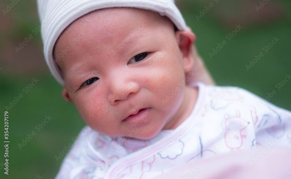 Portrait of a newborn baby infant hold close by mother in the garden, close up. Family, Portrait of a newborn baby infant hold close by mother in the garden, close up. Family,