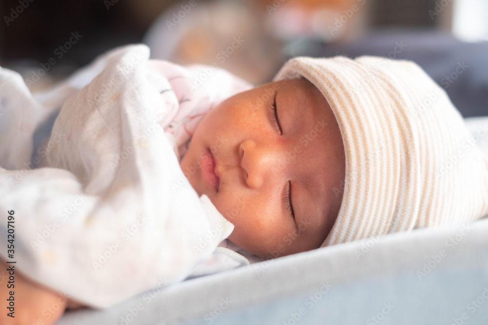 The Sleeping cute New Born Baby infant with hat on the bed. The Sleeping cute New Born Baby infant with hat on the bed.