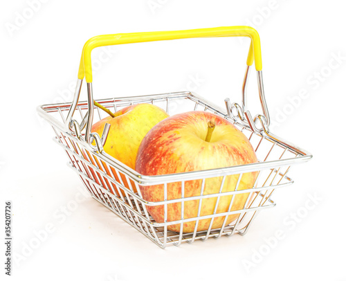 a small shopping basket with fruits, apples, on a white background. Healthy food, vegetarian food, vegetables, shopping at the supermarket.