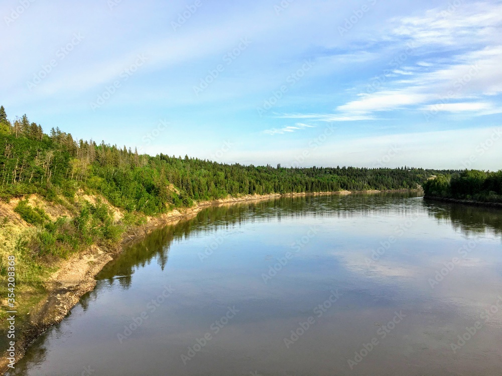 A beautiful photo of a gorgeous blue coloured river surrounded by green forest. This is the North Saskatchewan River, in Edmonton, Alberta, Canada. A beautiful photo of a gorgeous blue coloured river surrounded by green forest. This is the North Saskatchewan River, in Edmonton, Alberta, Canada.