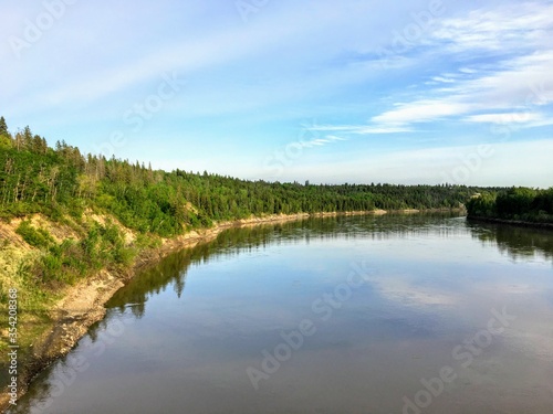 A beautiful photo of a gorgeous blue coloured river surrounded by green forest. This is the North Saskatchewan River, in Edmonton, Alberta, Canada.