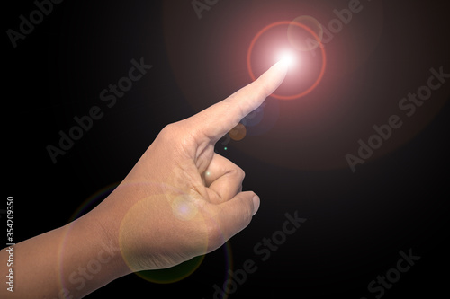 The hand is pointing at the finger, there is light at the fingertips. on black background