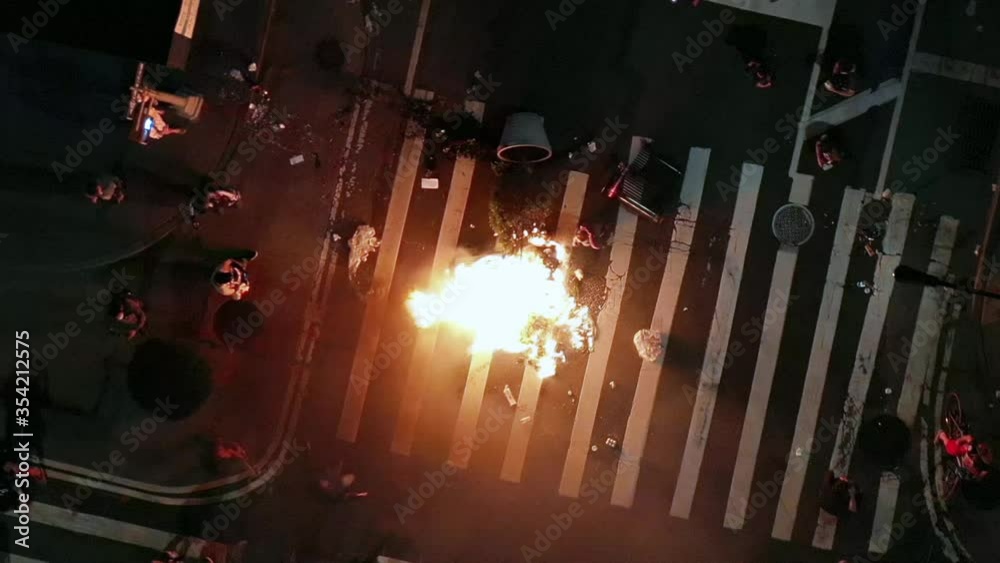 protestors lighting fire in crosswalk intersection after police officers killed , people take to the streets in New York City NYC
