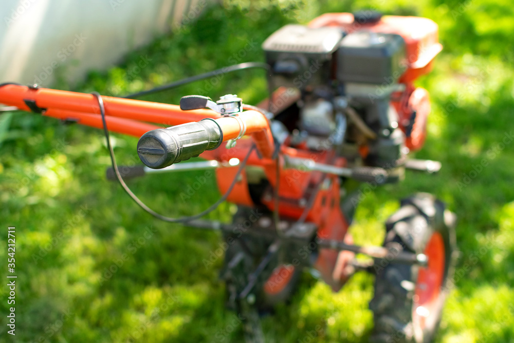 Man Farmer plows the land with a cultivator. Agricultural machinery: cultivator for tillage in the garden,motor cultivator