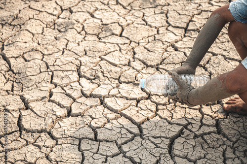 The little boy waiting for drinking water to live through this drought, Concept drought and crisis environment.