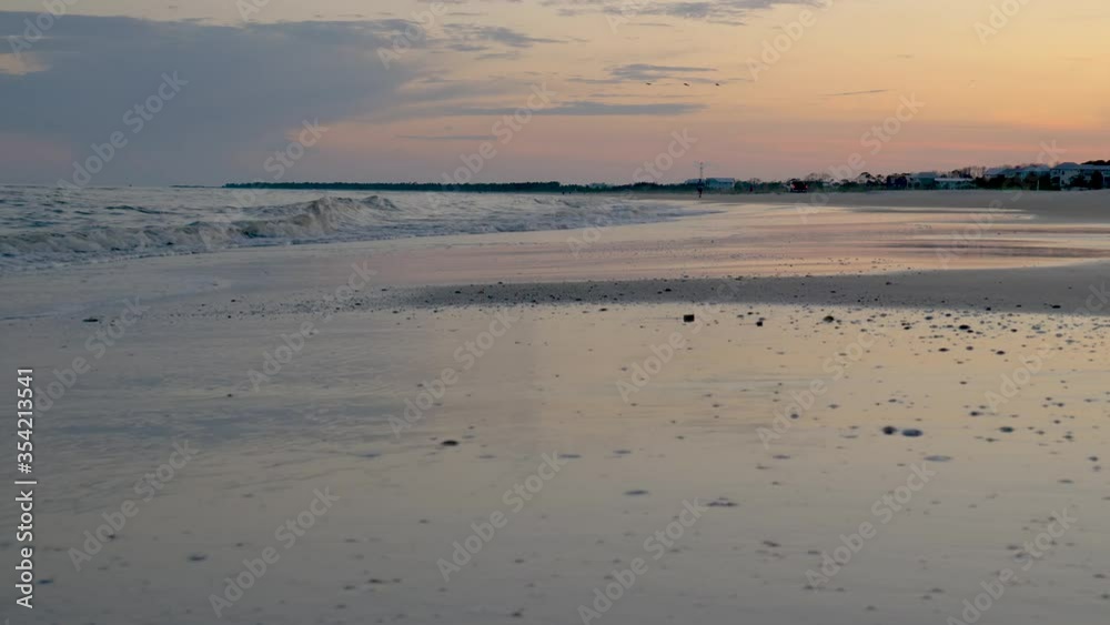 Low angle sand beach with waves and sunset sky landscape Low angle sand beach with waves and sunset sky landscape