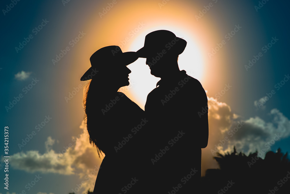 Silhouettes of men and women against the backdrop of the setting sun.