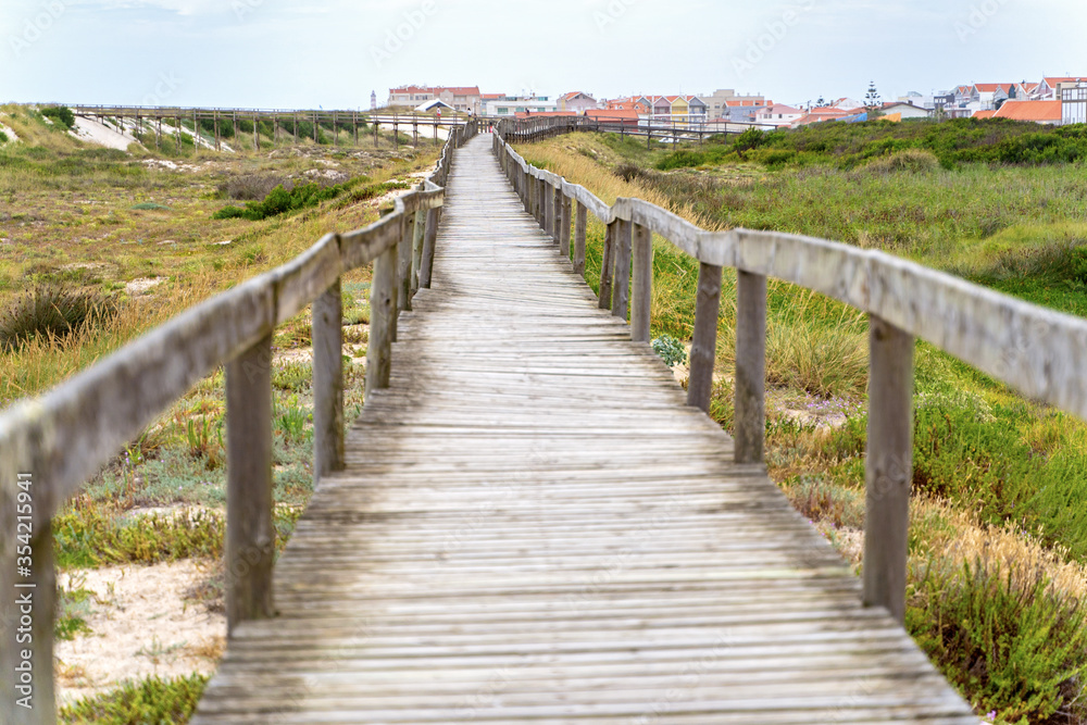Wooden path at over sand dunes. Wooden footbridge of Costa Nova beach in Aveiro, Portugal.