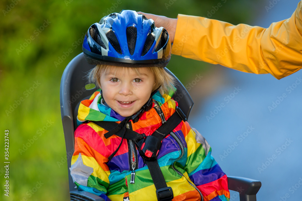 Mother and child, riding bike, boy sitting in bike seat, enjoying trip with mom, safety first Mother and child, riding bike, boy sitting in bike seat, enjoying trip with mom, safety first
