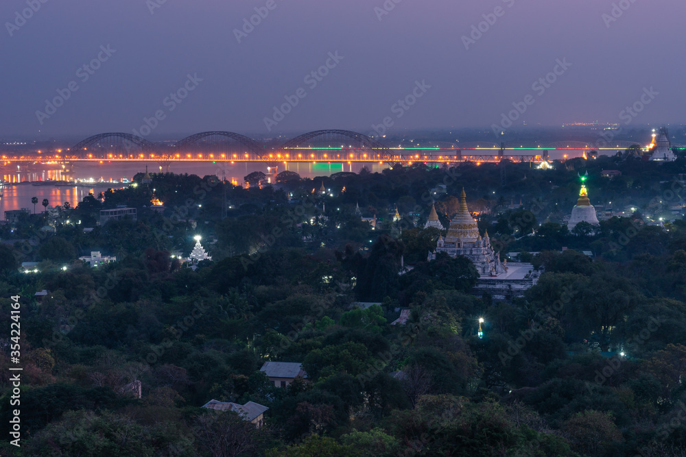 Sagaing city at night with Buddhist temple and bridge crossing Irrawaddy river, Mandalay, Myanmar
