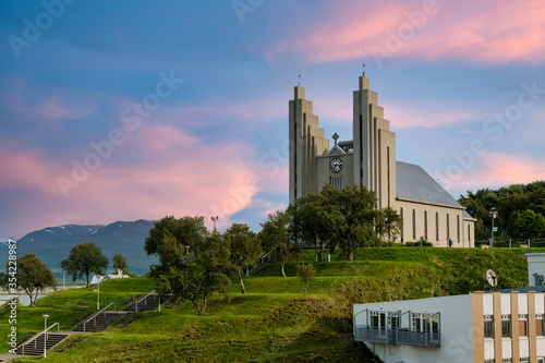 Obraz na płótnie Akureyrarkirkja Lutheran Church This is an important and popular landmark of Akureyri city in Northern Iceland, in the evening sky blue vanilla. In the summer there are trees and green grass. w salonie